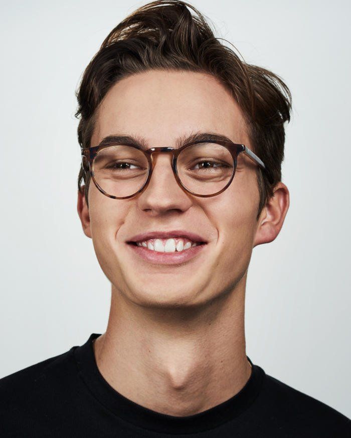 Smiling student in glasses on a light background