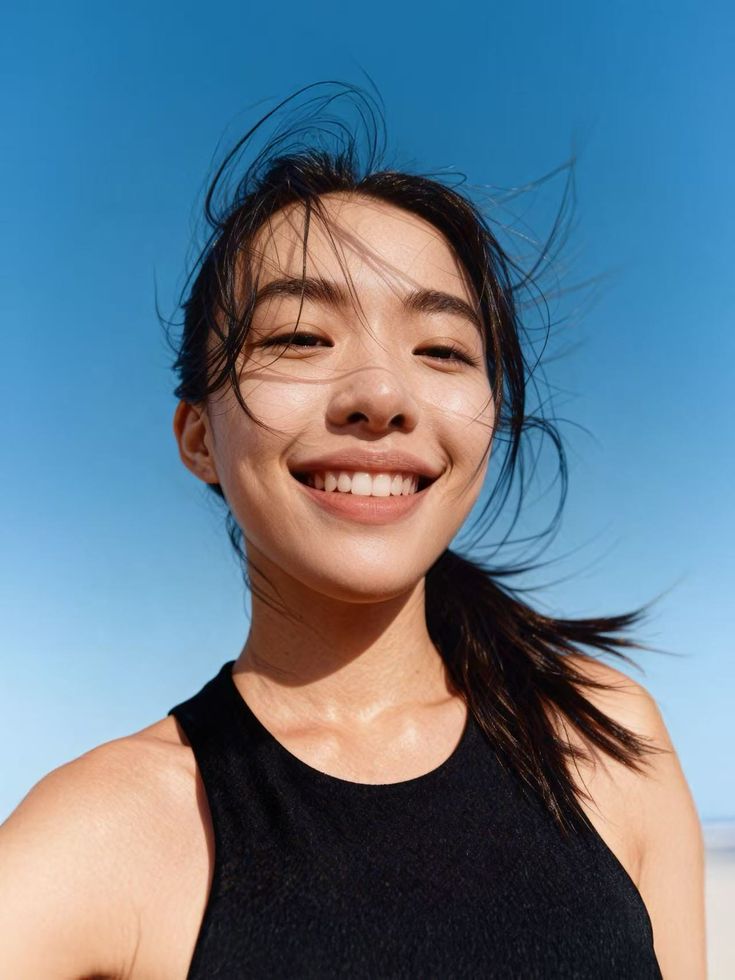 Smiling student outdoors against a clear blue sky