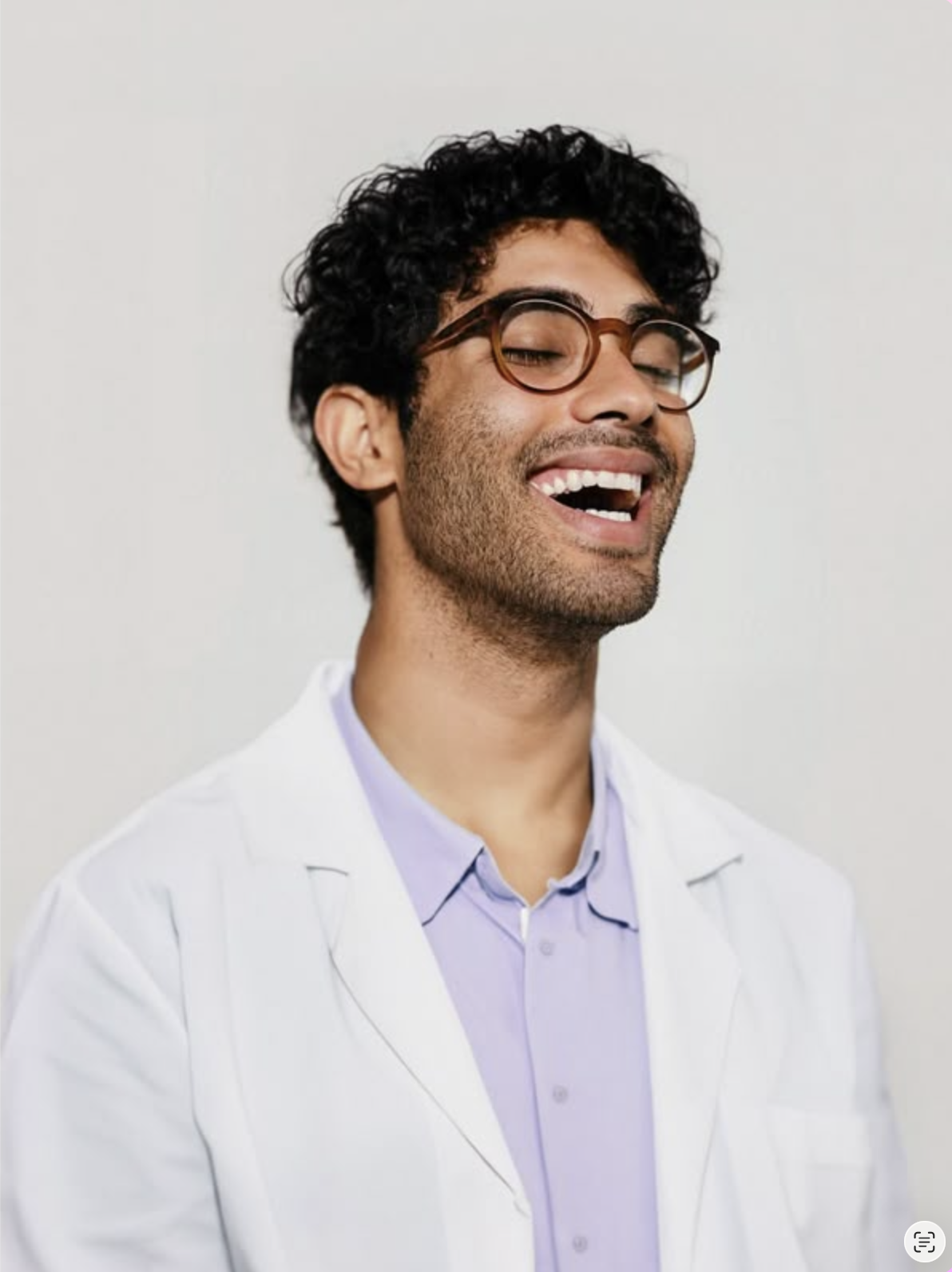 Laughing medical student in a white coat